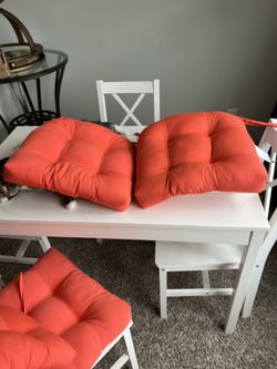 Orange cushions for wooden chairs