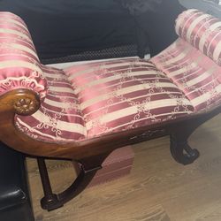 This is an antique or vintage chaise lounge with a pink and white striped damask upholstery