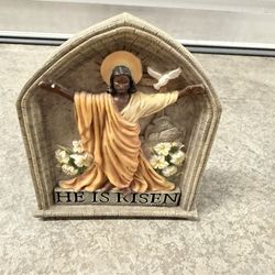 "He Is Risen" figurine, which symbolizes the resurrection of Christ.