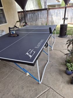 Eastpoint Ping pong table with paddles and a box of ping pong balls