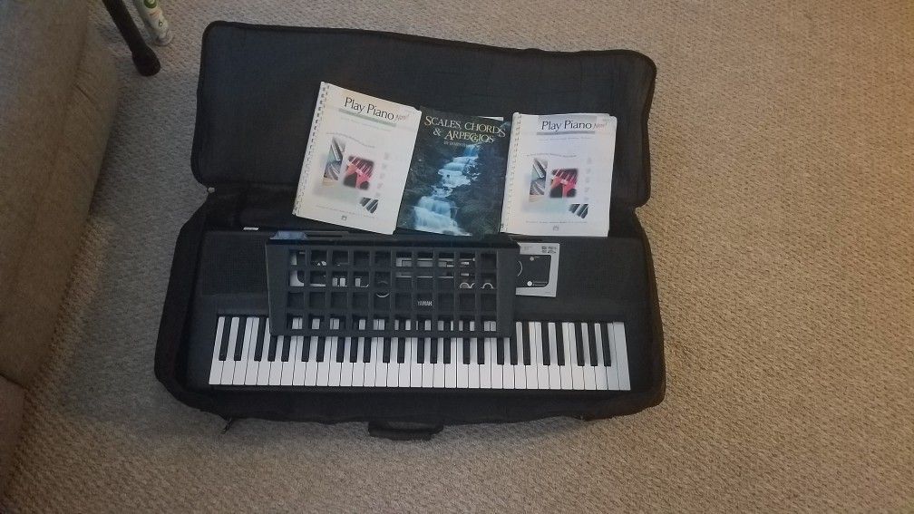 Electric keyboard with case and music books