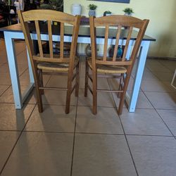 table with iron base and two wooden chairs
