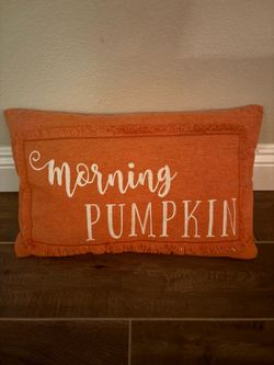 Festive orange lumbar pillow  with a  fringed border and the playful Fall morning PUMPKIN