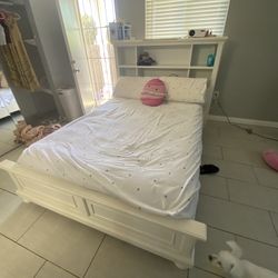 Full size bed with shelving and outlets