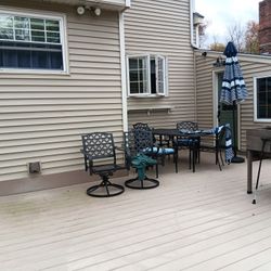 6 chairs and an outdoor table with an umbrella and stand