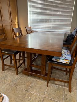Long counter height table with 8 chairs