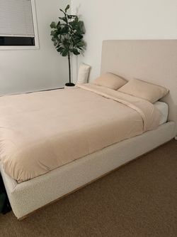cream/beige bouclé upholstered platform bed with a tall, rectangular headboard