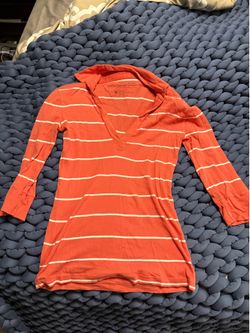 Lightweight coral orange shirt with white horizontal stripes.