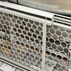 Gray baby gate with mesh design. Has a latch closure on the right side.