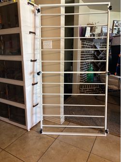White/cream metal twin-size roll-out trundle bed frame. Fits a standard twin mattress and rolls underneath a daybed,