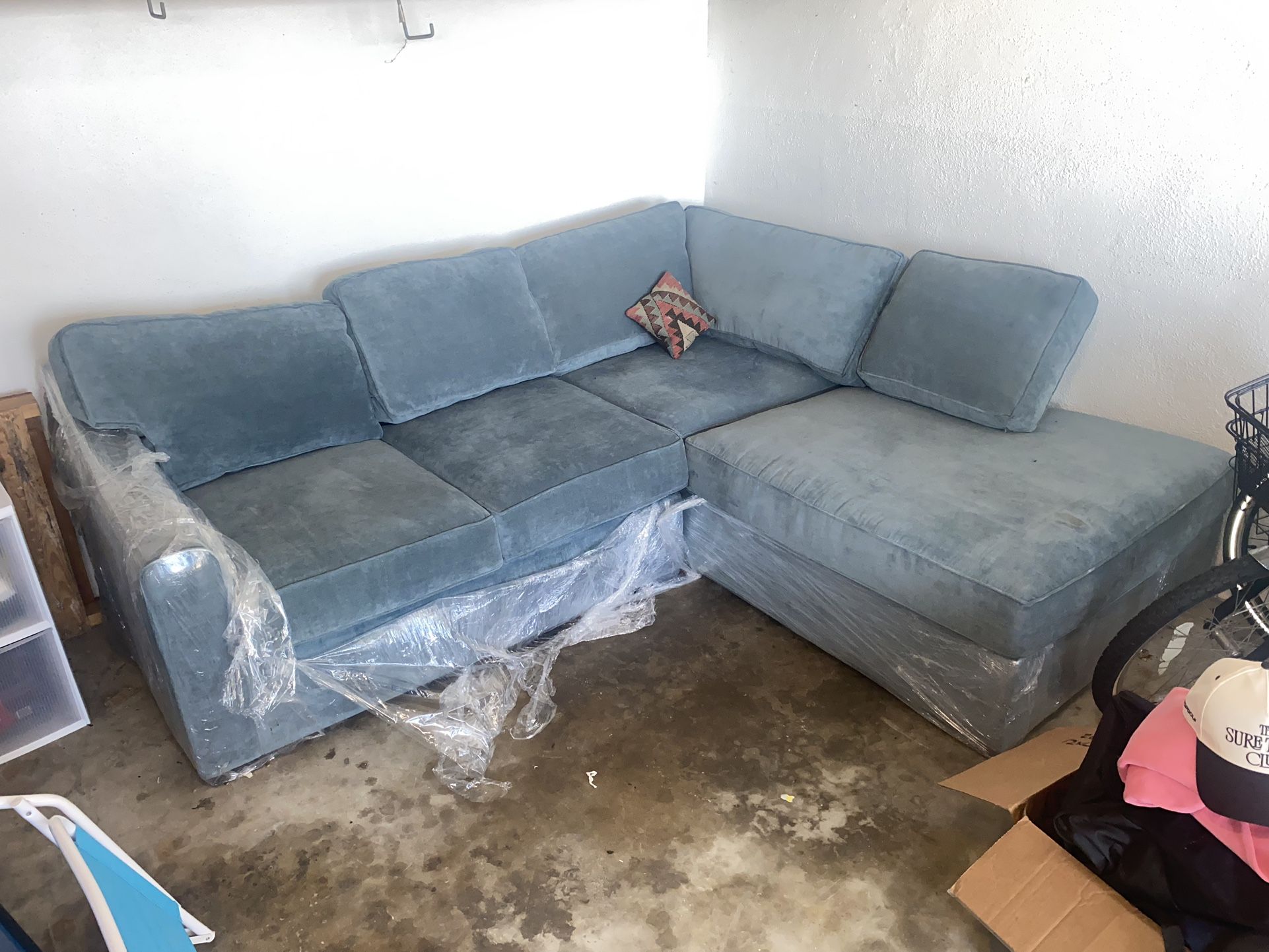 Like new couch from living spaces. Dark Teal. L shaped, chaise lounge. Still in plastic wrap. A beautiful staple that needs a new home to level up!