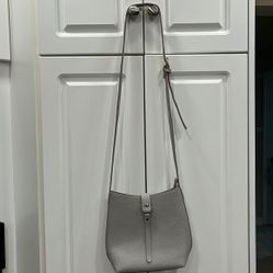 Grey small purse with cross body strap with zipper top and claps 