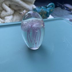 This item is a handcrafted glass jellyfish paperweight, likely from the Dynasty Gallery's glow-in-the-dark collection. 