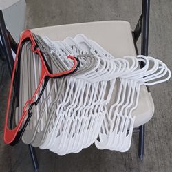 32  Mostly White Plastic Clothes Hangers. Not all are in the pictures. 