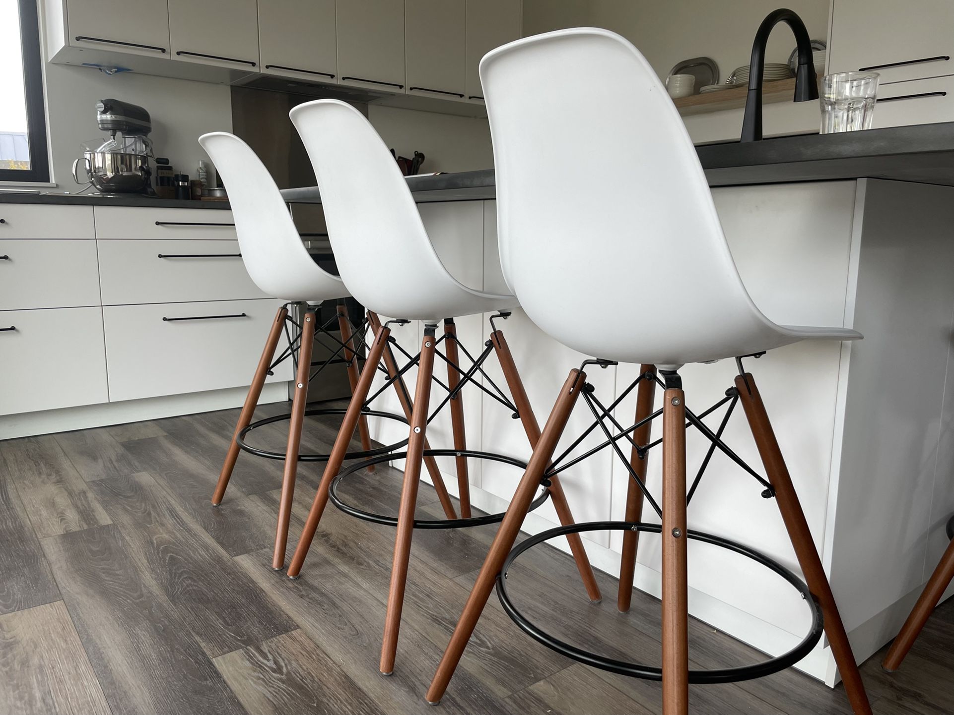 4 Reproduction Eames white molded plastic counter stools with walnut legs