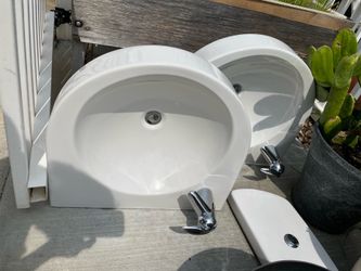 Two identical, like-new bathroom sinks—attractive and in good condition, complete with faucets. The cutout measures 16 1/2 inches in length; the total