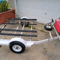 Large 2 jet ski trailer 8 feet by 14 feet, with gear box, gas can holder and spare tire. Have pink slip,current registration.