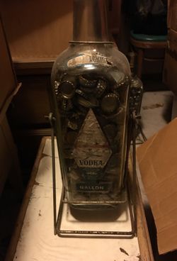 1 Vintage Vodka Bottle With Swinging Stand and filled with bottle tops