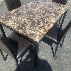 Four chairs and a thin marble top