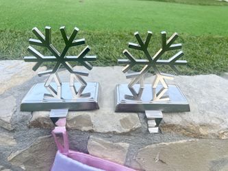 Set of 2 metal snowflake stocking holders. Sturdy and heavy, perfect for sitting securely on your mantle.