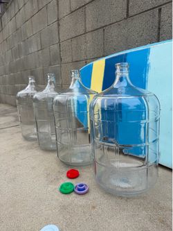 Four 5 Gallong glass water bottles