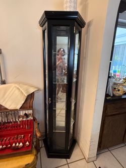 Dark wood curio chest with mirrored back