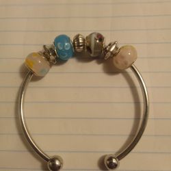 a cuff-style charm bangle featuring European-style glass beads. 