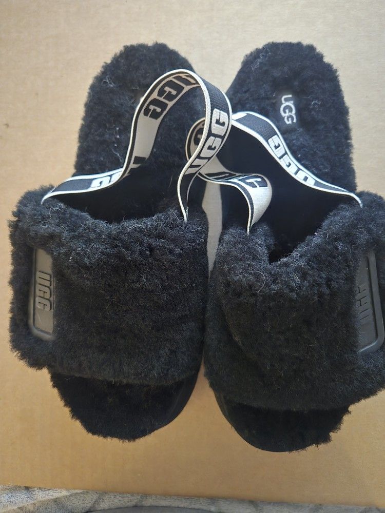 Black UGG slippers with white logo