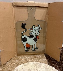 stylish, tempered glass cutting board featuring a charming cow and cowbell design.  All brand new in their boxes.