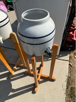 ceramic beverage dispensers (water, iced tea, lemonade, sangria, etc.) with wooden stands.
