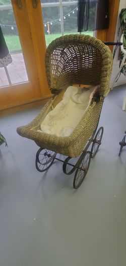 Antique wicker baby carriage with metal wheels.