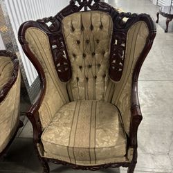 This is an ornate Italian Victorian-style carved wood wingback armchair with damask upholstery
