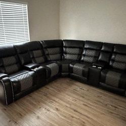 Black reclining sectional sofa upholstered in leather. Please inquire for the total price.
