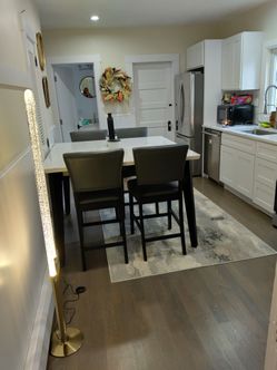 Marble top table with 6 dark grey chairs.