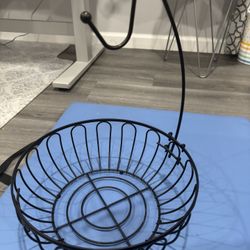 Black metal fruit basket with banana hanger.