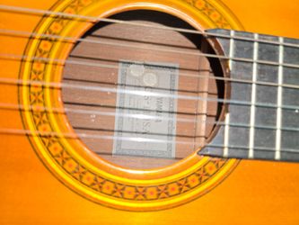 Yamaha acoustic guitar, stand, electronic digital tuner and two lessons books