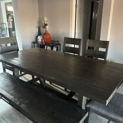 A comfortable dining room with 4 chairs and a heavy wooden bench in good condition