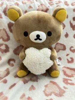 Rilakumma plush holding white heart