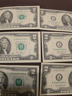 Two dollar bills with same letter on the serial number