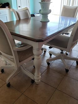 Dining wood set table includes four swivel rocker chairs. white color . 