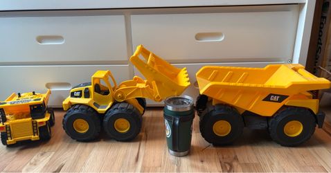 Caterpillar tough tracks plastic construction set. Never used outdoors. Plus remote control dump truck. 20 ounce coffee cup shown for scale.