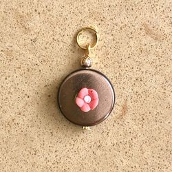 🟤 Pretty bronze colored beaded pendant with tiny, ceramic peach orange coral colored flower