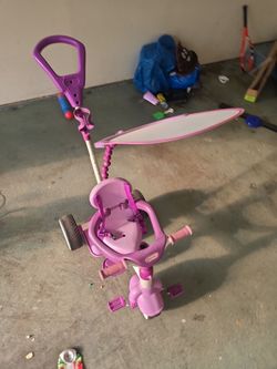 Kids push tricycle with shade.