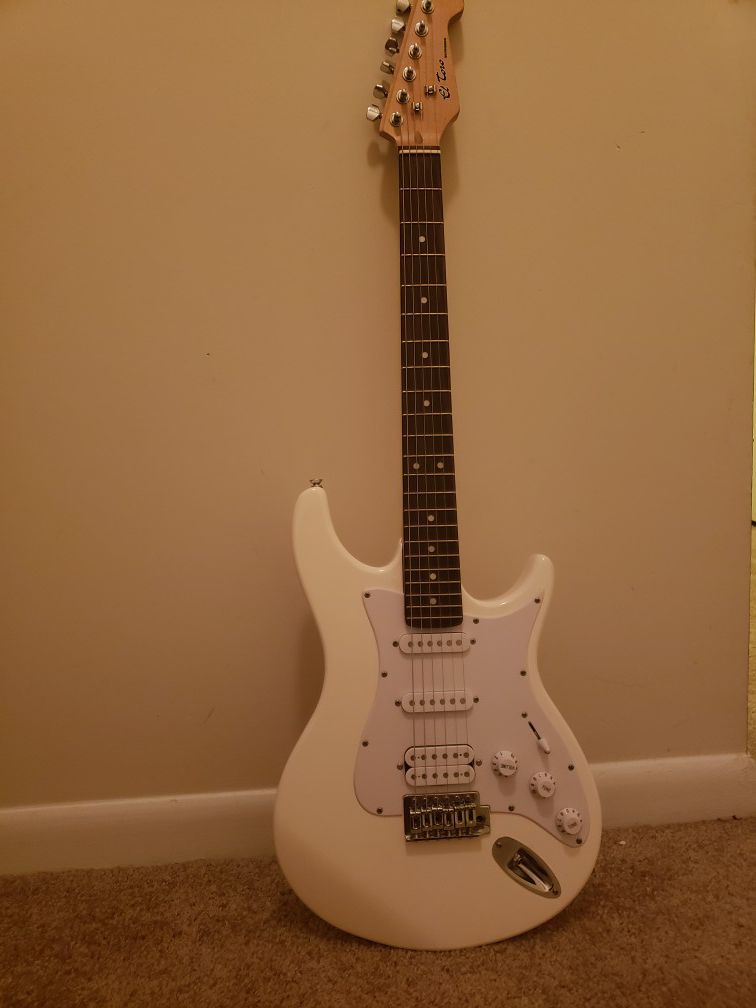 A behringer guitar with a behringer speaker and 12 extra strings with 2 guitar pics all for $150