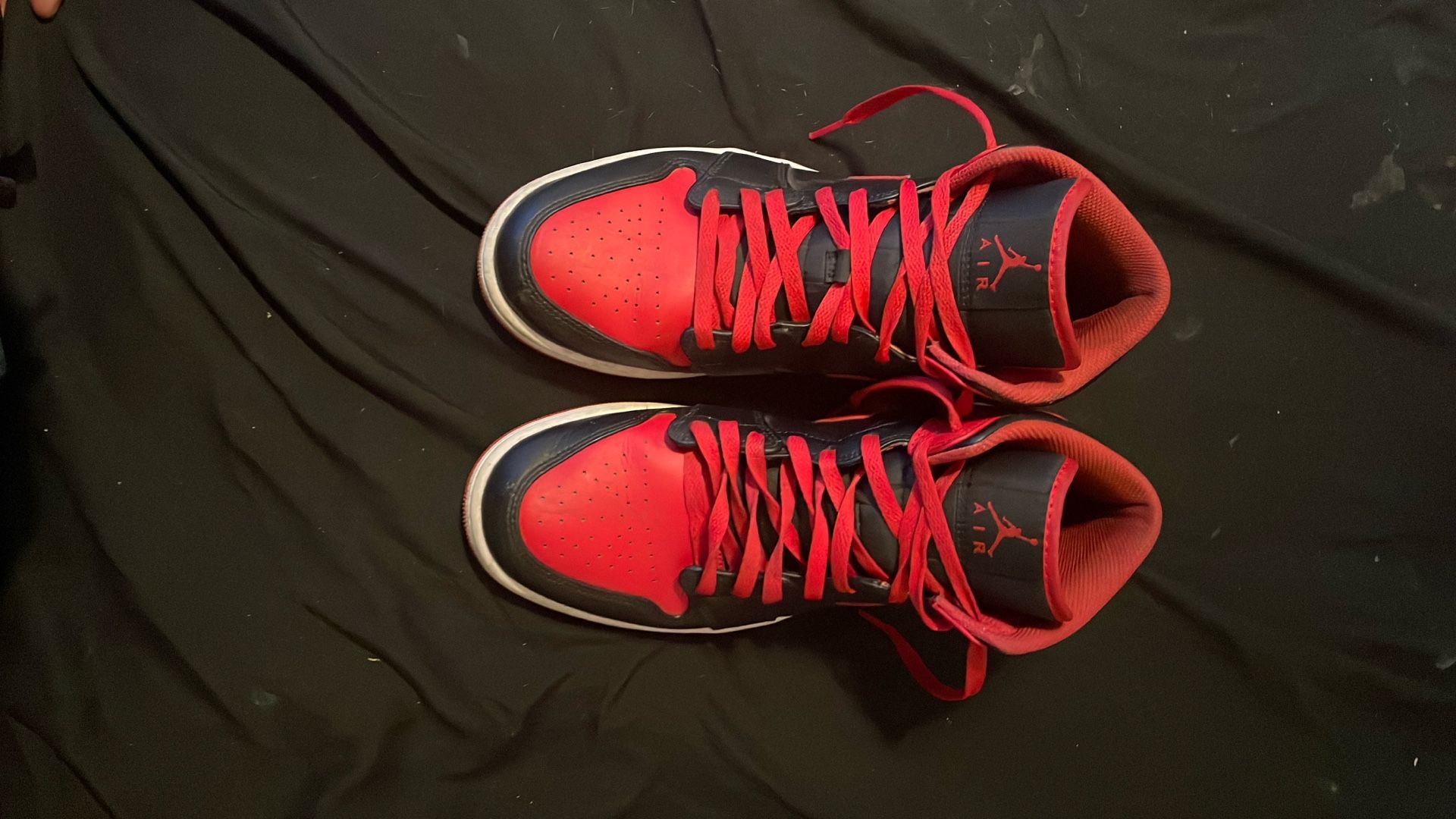 Nike Air Jordan 1 Mid "Alternate Bred" sneaker in a black, fire red, and white colorway. 