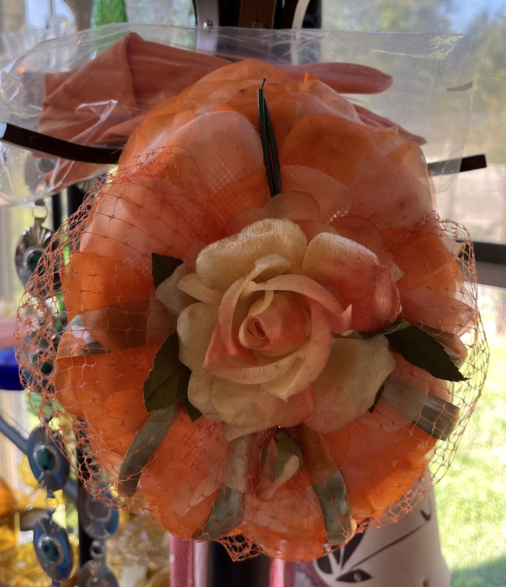 Vintage (1960’s) Orange fascinator Decorative Formal hat with floral and netting details.