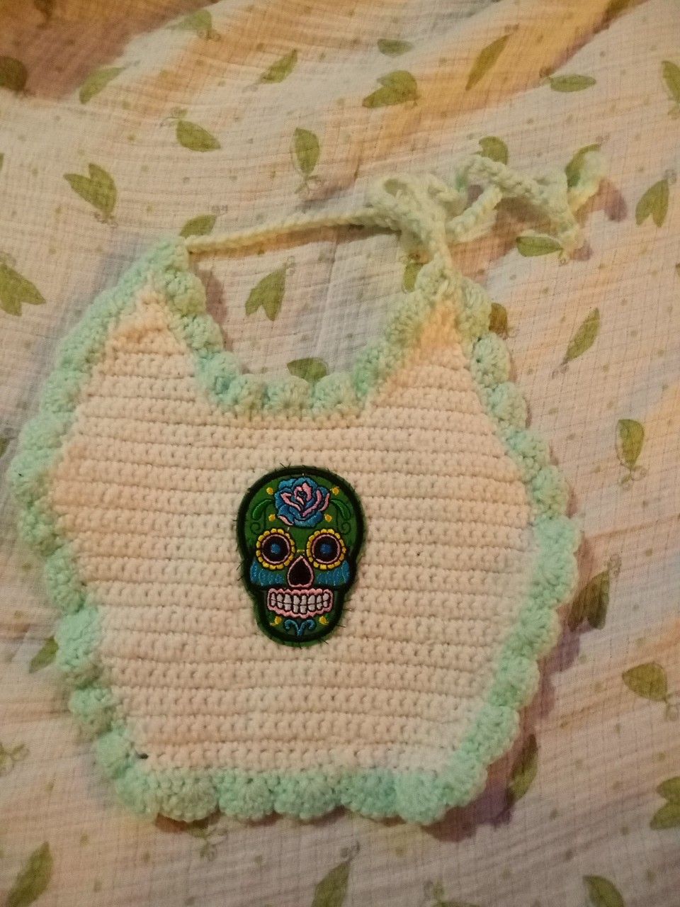 Hand-knitted sugar skull baby bib