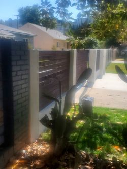 A sliding door with motor 1 metal fences with wood and the small entrance door.