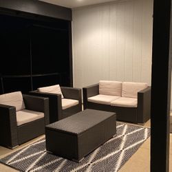 Outside couch and single seats with Cushions and a table