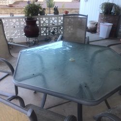 Patio Glass Table & 6 Chairs (Glass Table Has A Pattern On It & The Chair Have A Spring Like Rock To Them)